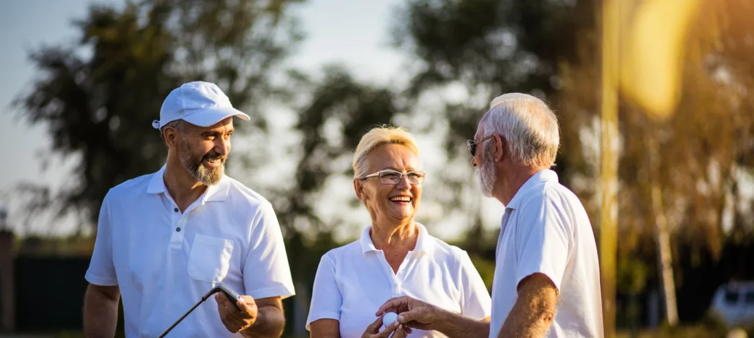 Three golfers enjoying a round together in the afternoon sun