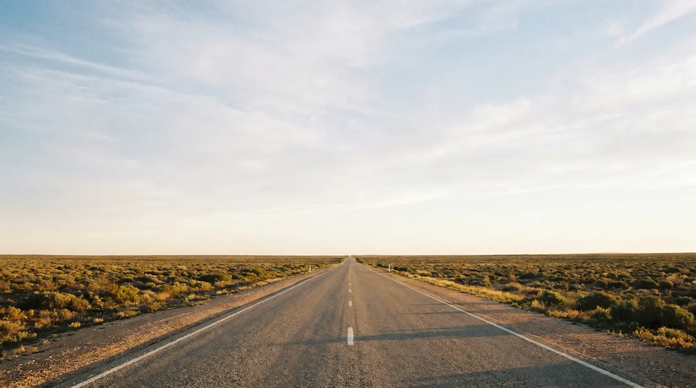 A long straight stretch of sealed highway crossing the treeless Nullarbor Plain